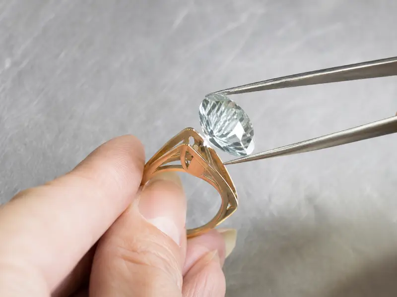 Gemstone being positioned in a jewelry ring setting