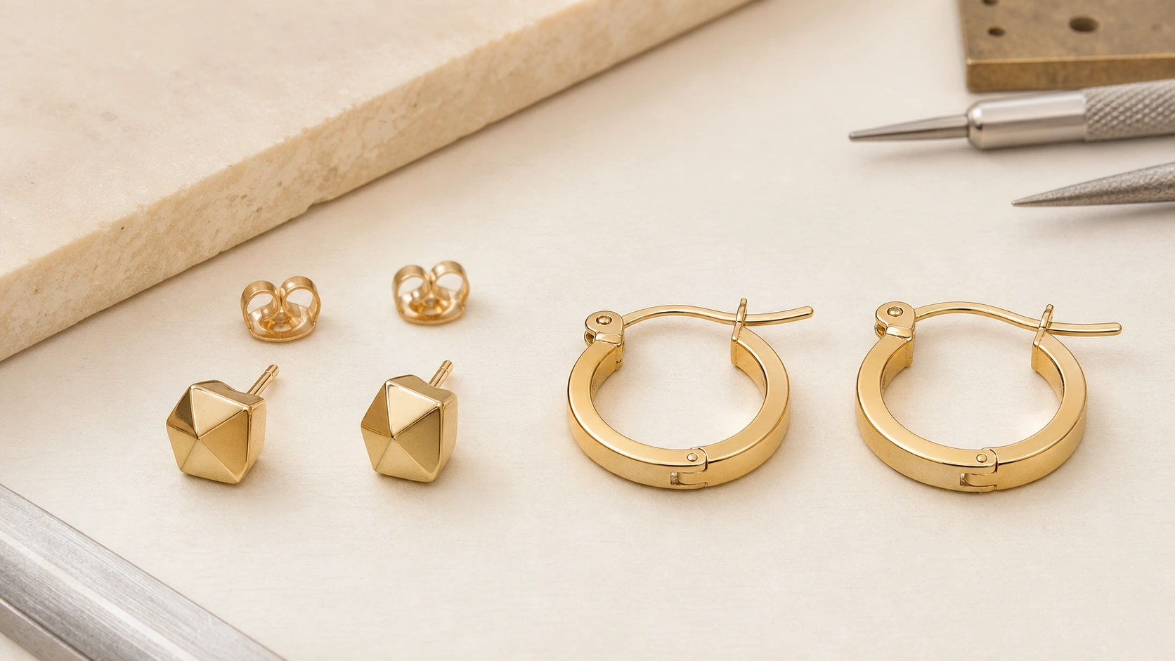 Stud earrings and hoop earrings compared on a jewelry brand development worktable